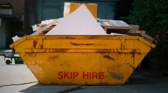 A yellow skip hire container, used for waste disposal and transportation purposes